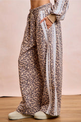 Leopard print pants with white stripes on a plain background