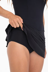Black ruffle bottom tennis dress with built in shorts cross cross back detail and tiered ruffle back detail discreet back zipper.