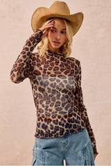Person wearing a leopard print long-sleeve top and beige cowboy hat against a beige background