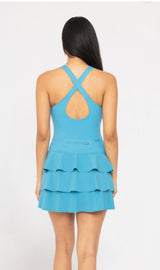 Blue ruffle bottom tennis dress with built in shorts cross cross back detail and tiered ruffle back detail discreet back zipper. 