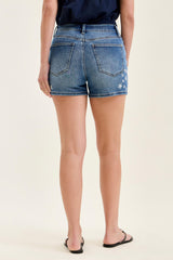 Person wearing blue denim shorts on a beige background